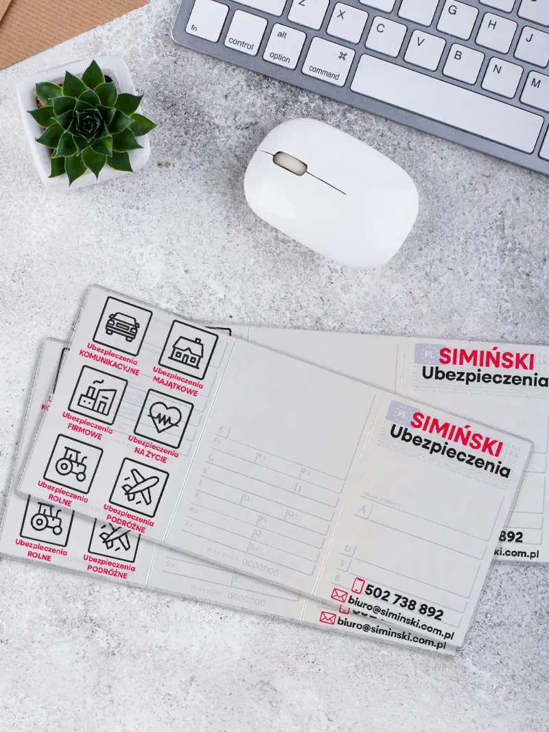 Zbliżenie na wnętrze okładki na dowód rejestracyjny prezentujące sześć ikon kategorii ubezpieczeń, ułożonej na jasnym blacie obok białej myszki.