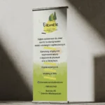 Roll-up reklamowy Elemele z motywem lasu, ustawiony na teksturowanej ścianie w Ostrowie Wielkopolskim.